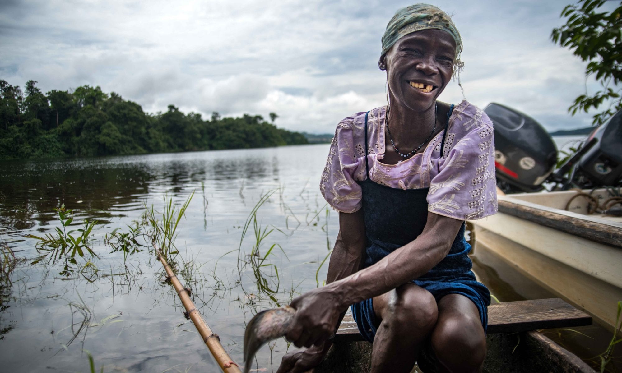 Woman fisher cleaning and cooking fish on Aschouka on Lake Oguemoué